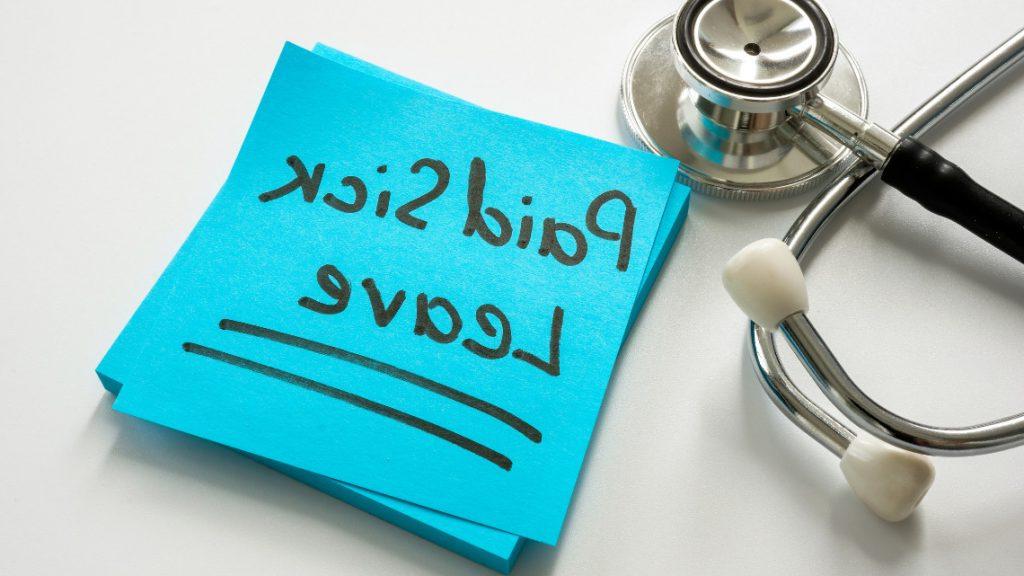 image of a stethoscope sitting next to a post-it note with the words 'paid sick leave' written on it